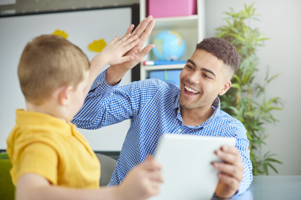 teacher and student in class giving high five